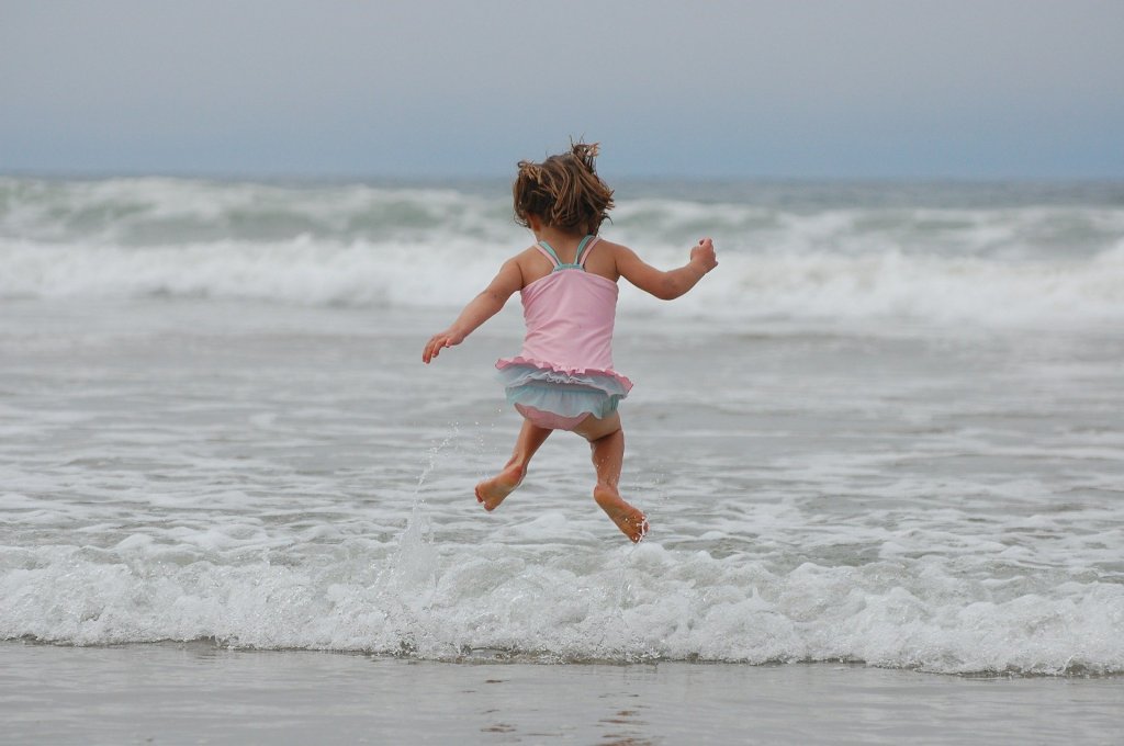 toddler jumping into the ocean waves