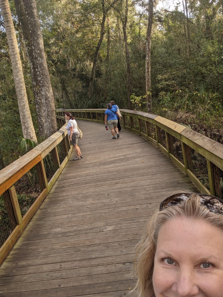 Author selfie, three dear friends on a boardwalk ahead on the nature trail, looking at the sights