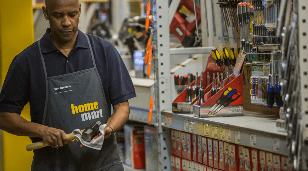 screenshot of Denzel Washington in The Equalizer at work wearing a home mart apron